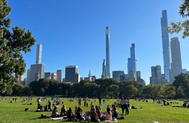 People enjoy the sun on the grass of Central Park, Manhattan, New York city, on October 16, 2022. (Photo by DANIEL SLIM/AFP via Getty Images)