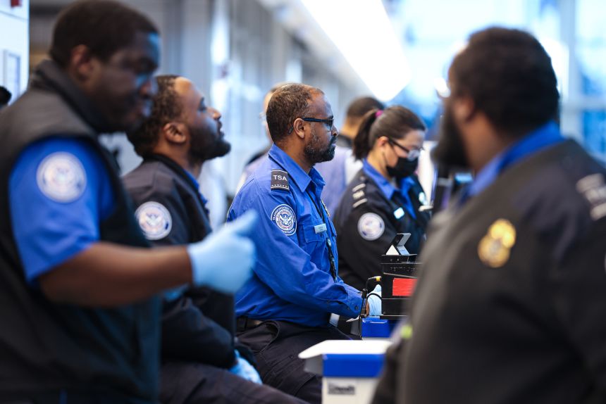 Transportation Security Administration agents sit as they check boarding passes and IDs at Ronald Reagan Washington National Airport, on Monday, January 26, 2026.