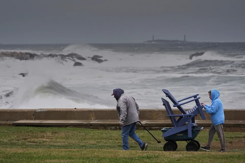 Chuck and Teresa Palmieri move lawn furniture to a safe location at a relative's seaside property in Gloucester, Mass., on Friday.