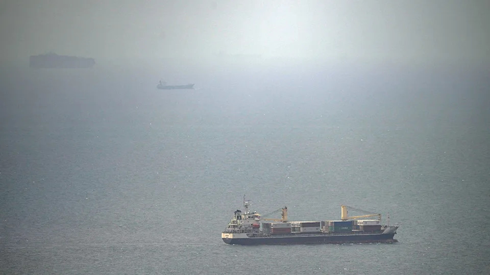 A cargo ship sailing on the water in the Persian Gulf.