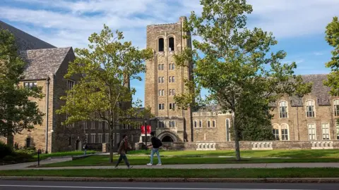 Getty Images A stone building on the Cornell campus as students walk nearby