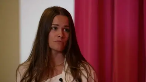 BBC  Brittany Bee is seen talking with a reporter. 