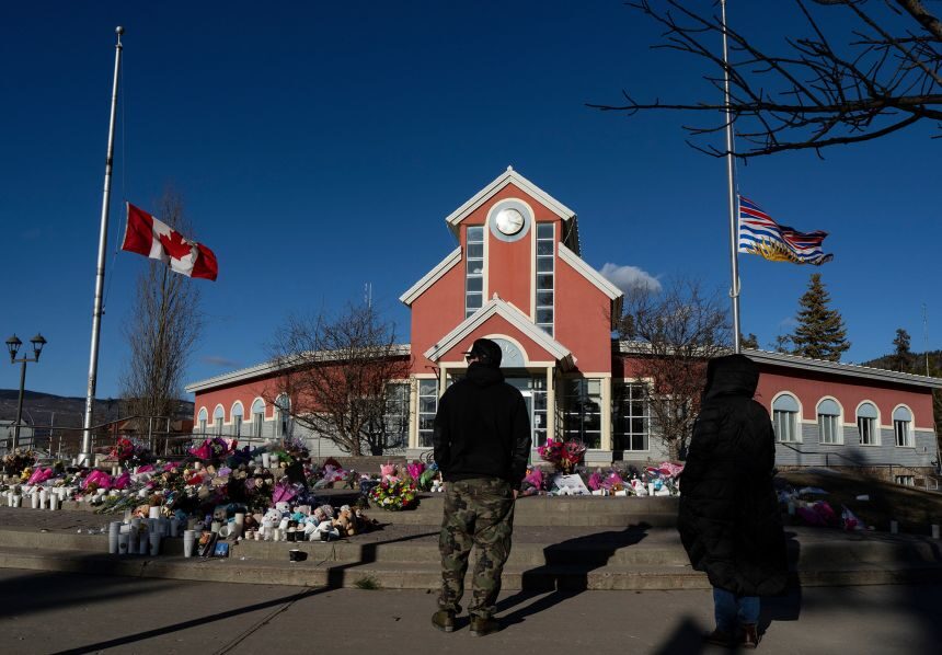 People pay their respects at a memorial on the steps of the Town Hall, following a vigil the previous day, in Tumbler Ridge, British Columbia, Canada, Feb. 14, 2026.