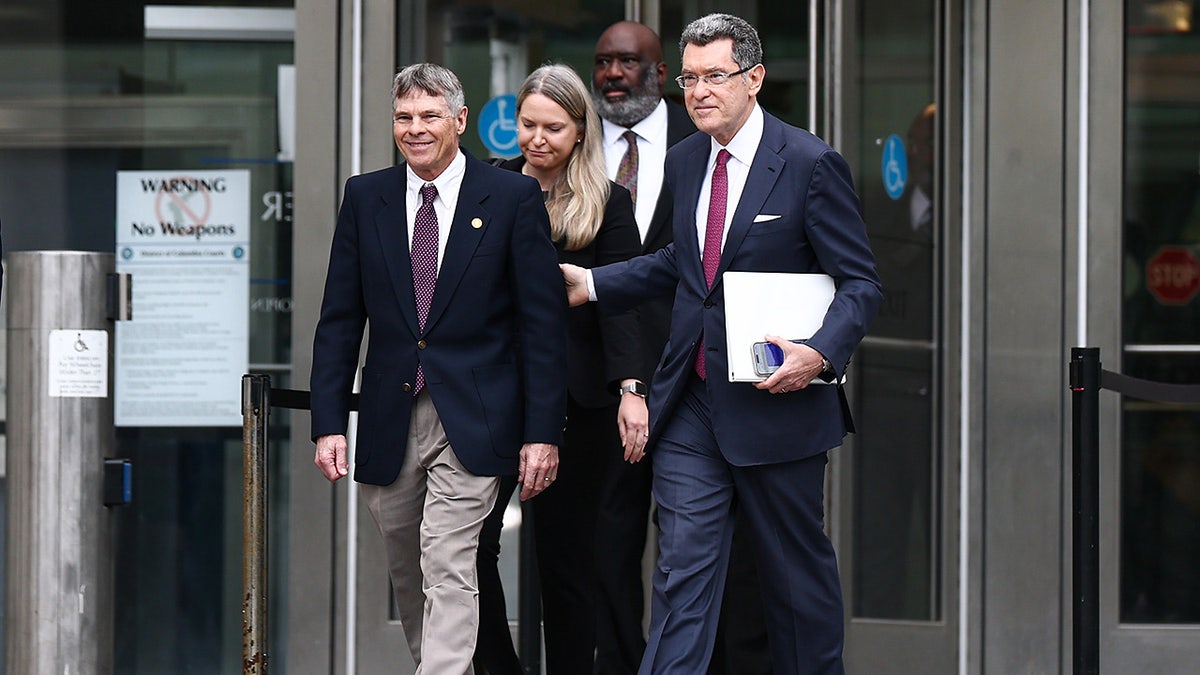 Former Olympian David Hearn walks with his attorney